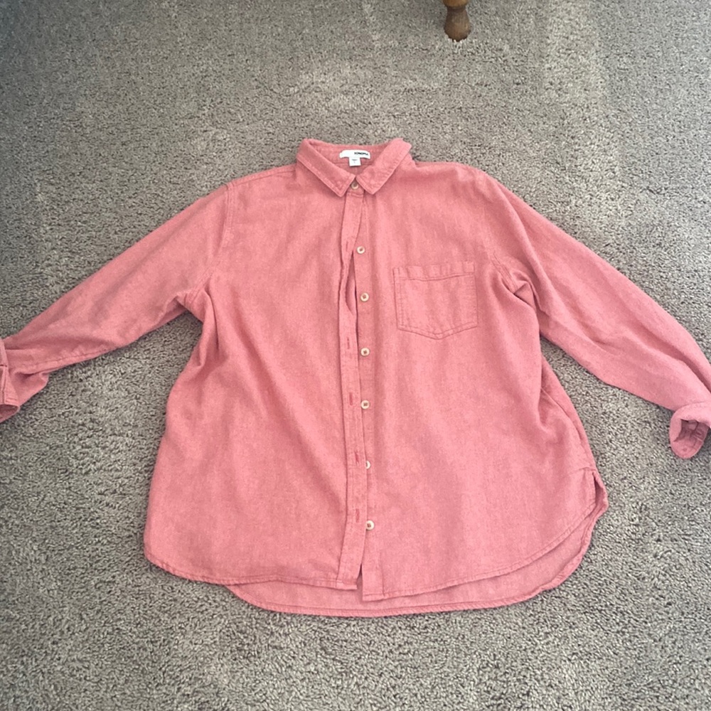 Woman’s salmon color button up shirt